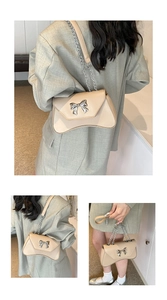 Detailed view of women's crossbody bag featuring silver metal bow and chain strap
