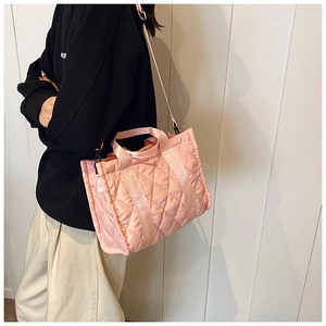 Pink quilted crossbody bag detail showing the puffy nylon texture and adjustable shoulder strap
