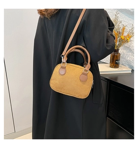 Detail view of a vintage tan velvet pillow handbag with round handles and metal hooks