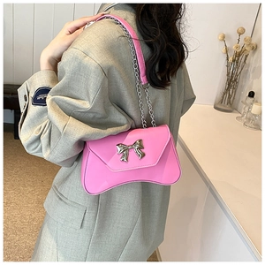 Detail of pink PU leather shoulder bag with a silver butterfly metal buckle and chain