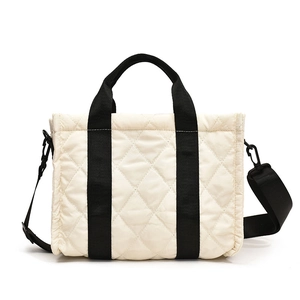 Chic quilted beige crossbody bag with contrast black straps and spacious design for daily use