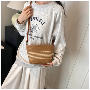 Detail view of woven straw shoulder bag with beige stripes for summer beach vacation
