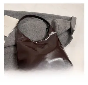 Detail showing deep brown glossy leather texture of the spacious vintage hobo tote bag