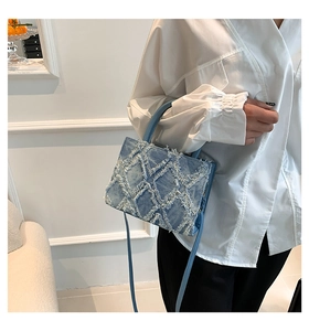 Detail of light blue denim tote bag featuring textured white fringe diamond pattern