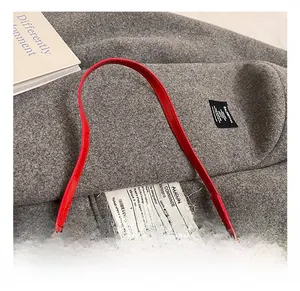 Detail of leopard print handbag with chic red leather handle and creative tag design