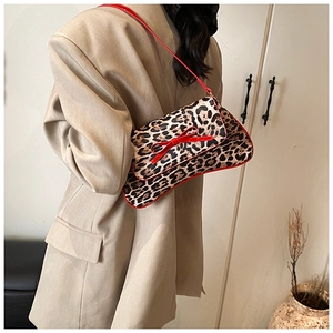 Chic leopard print baguette bag with red bow detail worn by model in oversized blazer
