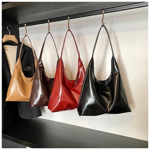 Detailed display of glossy vintage underarm bags in four colors hanging on a rack