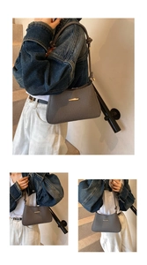 Gray textured shoulder bag featuring gold hardware detail and a chic trapezoidal shape