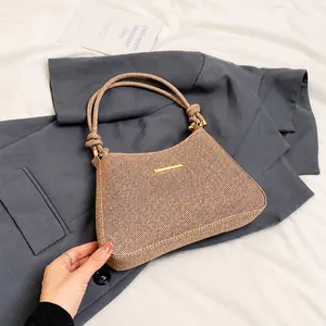 Detail view of woven brown hobo bag with rope shoulder strap and gold hardware accents