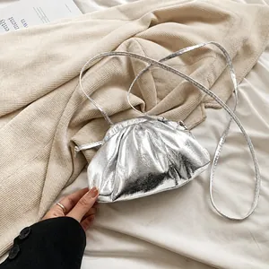 Detail shot of metallic silver cloud bag showing gathered pleats and shiny finish