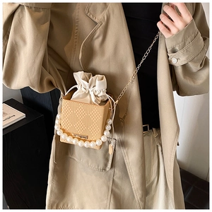 Detaillierte Makroansicht einer gewebten Box-Tasche mit Perlen und goldener Kette