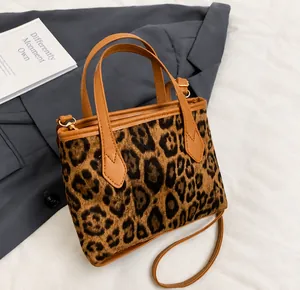 Détail de la texture léopard, poignée en similicuir et boucle métallique dorée du sac seau