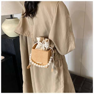 Elegante beige gewebte Box-Tasche mit Perlengriff und goldenem Kettenriemen am Model