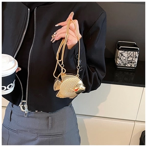 Detailansicht der goldfarbenen Mini-Tasche in Fischform mit Kette, getragen am Model