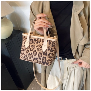 Dettaglio della trama leopardata e tracolla in pelle beige della borsa a secchiello moda
