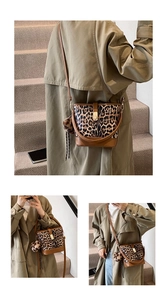 Detail of leopard print bucket bag featuring brown leather trim and gold metal hardware