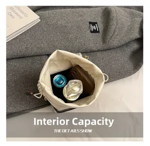 Detailed view showing the internal storage capacity of the cream pearl bucket bag