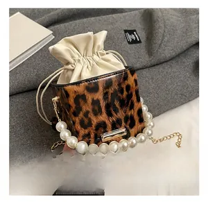 Detailed macro of leopard print mini bag with large pearl handle and golden chain strap