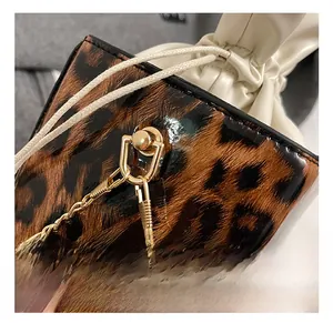 Detail showing leopard print texture with gold hardware and elegant pearl charm accents