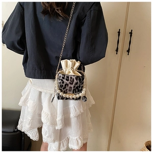 Detail of leopard print bucket bag with pearl handle and gold chain strap close-up