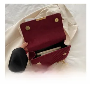 Detail view of burgundy quilted velvet bag showing internal capacity with a smartphone