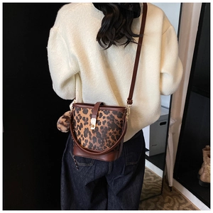 Détail du sac seau léopard avec boucle magnétique en métal et pompon décoratif