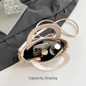 Vista interior que muestra la capacidad del bolso de cuero crema para objetos diarios