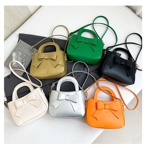 Dettaglio di borse alla moda con fiocco in vari colori tra cui crema e dorato