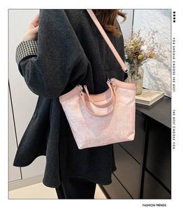 Detail of light pink silk embroidery tote bag with floral patterns and leather straps