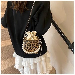 Detail der Leopard-Eimertasche mit Perlengriff und goldener Kette an der Schulter