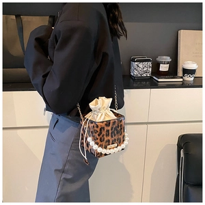 Mini-Umhängetasche mit Leopardenmuster, Perlengriff und Kettenriemen am Modell