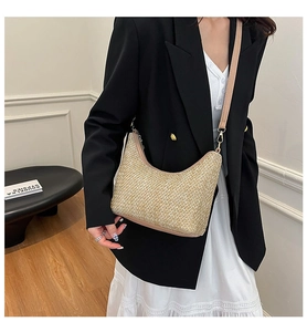 Détail du tissage fait main et bandoulière cuir sur ce sac en paille demi-lune kaki