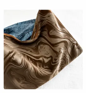 Close-up of brown marble pattern texture on a stylish ruched pillow bag for women