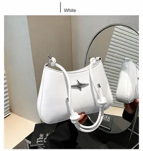 Detalle de bolso media luna blanco con adorno de estrella plateada y correa de nudos