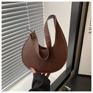 Detail of a vintage dark brown crescent shoulder bag with matte leather texture