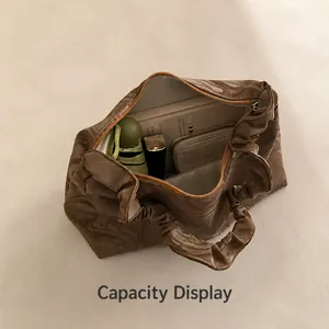 Macro view of the spacious internal storage capacity of the brown pleated shoulder bag