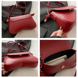 Detail view showing dark red leather crossbody bag with knotted strap and magnetic closure