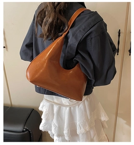 Borsa a mezzaluna marrone indossata da modella che mostra lo stile vintage e la pelle