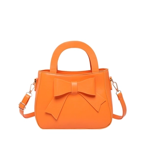 Sac à main orange tendance avec une grande décoration en nœud et des détails en métal doré