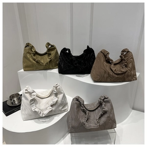 Close-up of ruched handle detail and pleated marble texture on stylish hobo bags