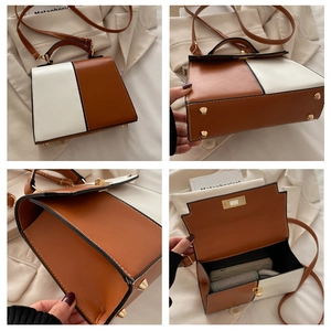 Detalle del bolso de mano bicolor con espacio interior y tachuelas de base metálicas