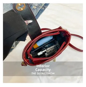 Détail de l'intérieur d'un sac seau bordeaux avec fermeture dorée et poche zippée