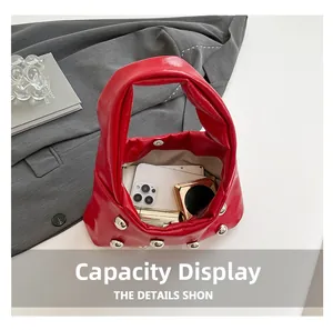 Detail view of red rivet crescent bag showing large capacity for phone and cosmetics