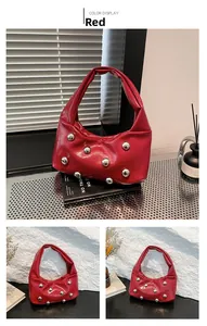 Detail of red faux leather shoulder bag with silver spherical rivets and pleated texture
