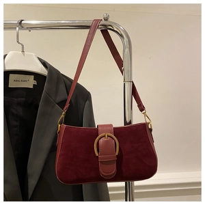 Détail du sac rétro bordeaux avec boucle dorée ovale et texture effet daim