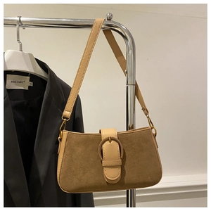 Détail du sac à main marron vintage en daim avec grande boucle en métal rond