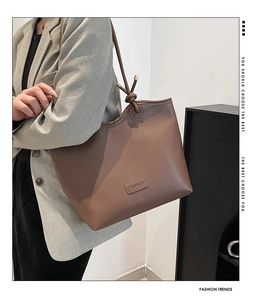 Detailed macro view of brown faux leather tote with embossed fashion lettering
