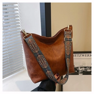 Detail of vintage brown tote bag featuring a wide bohemian embroidery shoulder strap
