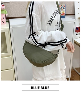 Deep green crescent crossbody bag worn by model showing casual lightweight nylon material