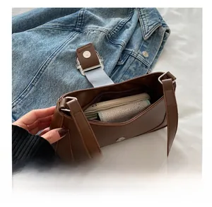 Brown leather baguette bag showing internal capacity for phone and small wallet
